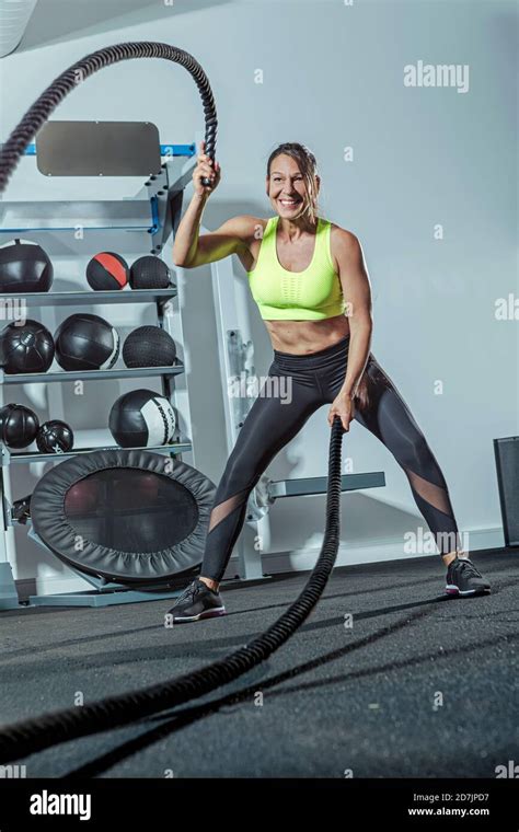 Smiling Mature Woman Exercising With Battle Rope In Gym Stock Photo Alamy