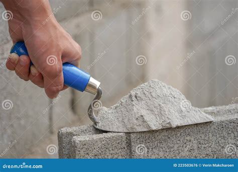 Hand Of Industrial Bricklayer Hold Aluminium Trowel Scoop Mortar Put On