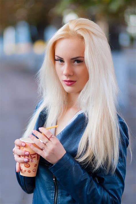 La Belle Jeune Fille Blonde Avec Un Joli Visage Et Un Beau Sourire Observe Le Portrait D Une