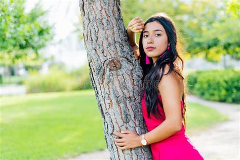 Jovencita Latina Brunette Con El Pelo Largo Negro Y Los Ojos Negros Con Un Vestido Rojo Mirando