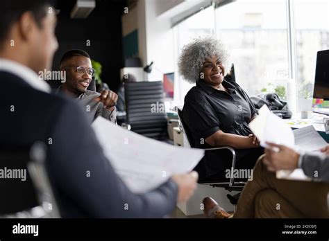 Happy business people talking in office meeting Stock Photo - Alamy