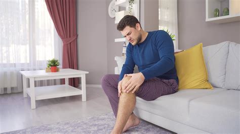 Young man with aching leg suffers from disability. Man in pain and