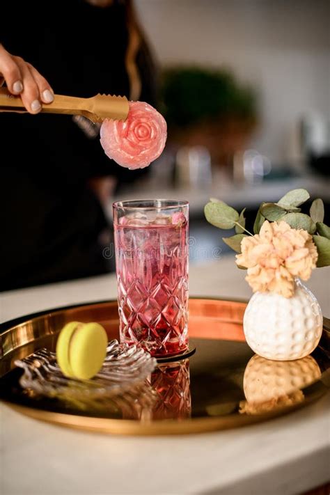 Woman Waitress With Neat Nude Manicure Holding Tweezers And Decorates Glass With Lemonade Or