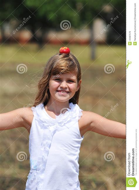 Equilibrio Feliz De La Muchacha Con La Manzana En Su Cabeza Foto De