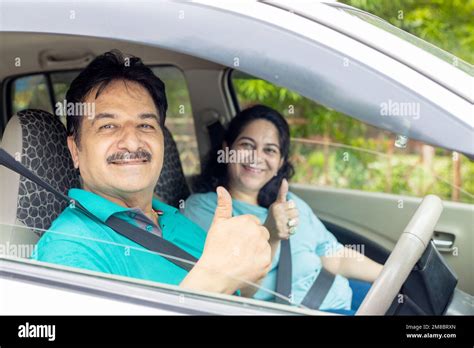 Happy Indian Mature Couple Sitting In Car Wearing Seat Belt Do Thumbs