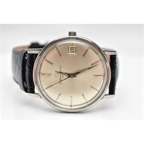 AN 'ETERNA-MATIC' WRISTWATCH, hand wound movement, round silver dial ...