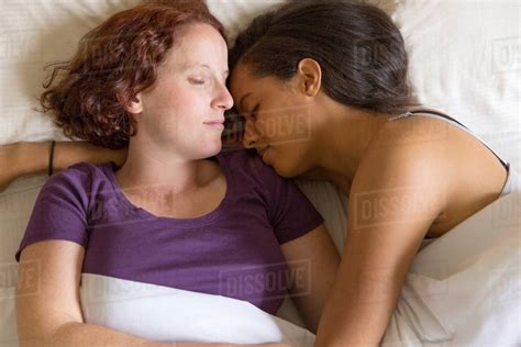 High Angle View Of Lesbian Couple Lying In Bed Hugging Sleeping Royalty Free Stock Photo