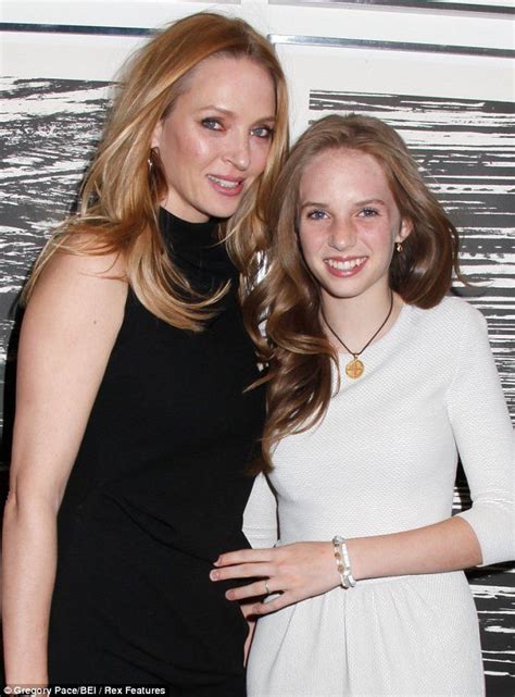 Two Women Standing Next To Each Other In Front Of A Wall