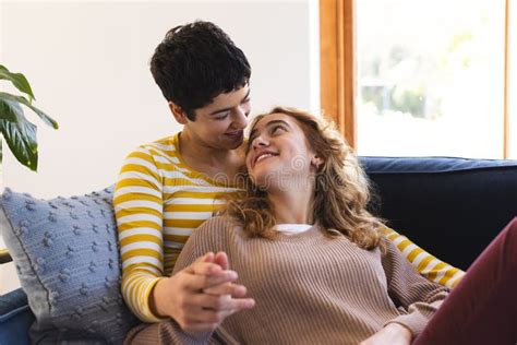 Happy Biracial Lesbian Couple Relaxing On Couch Together Embracing At Home Stock Image Image