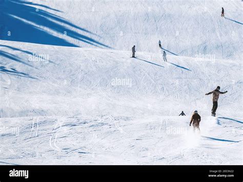 Skiers and snowboarders riding down a steep slope Stock Photo - Alamy