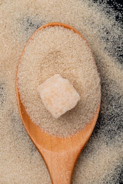 Free Photo Top View Of A Wooden Spoon With Brown Sugar And Sugar Cube