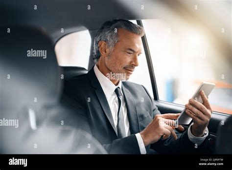 Taking His Work Along For The Ride A Handsome Mature Businessman Using A Tablet While Sitting