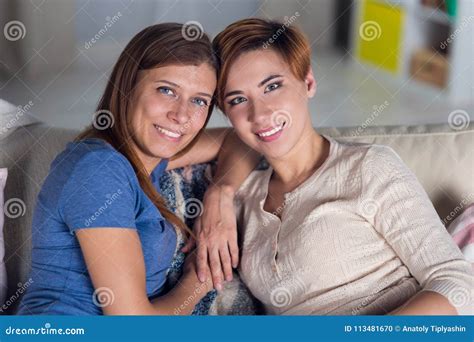 Homosexual Couple Of Lesbian Women At Home On The Couch Hugging Stock Photo Image Of Life