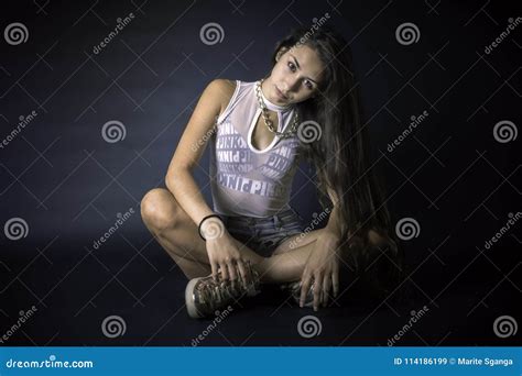 Retrato De La Mujer Latina Hermosa Joven Que Pone Sobre Un Fondo Negro Imagen De Archivo