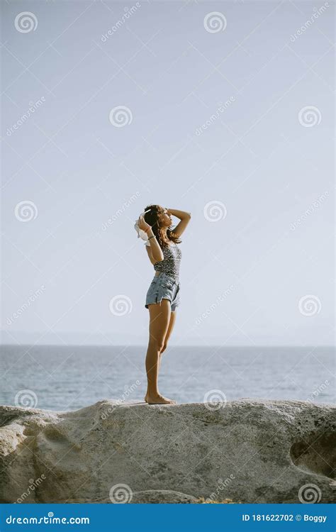 Junge Frau Im Bikini Auf Stein Durch Das Meer Steht Stockfoto Bild Von Meer Freizeit