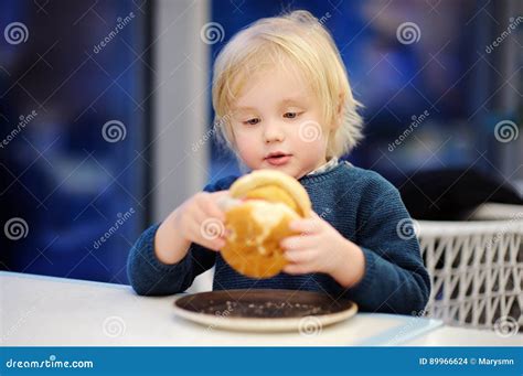 Cute Blonde Boy Eat Hamburger At Fast Food Restaurant Stock Photo Image Of Holding
