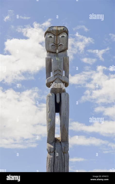 Maori Traditional Carved Wooden Pou Or Guardian Outside A Marae In