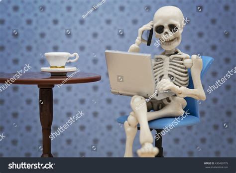 skeleton talking smartphone  working laptop stock photo