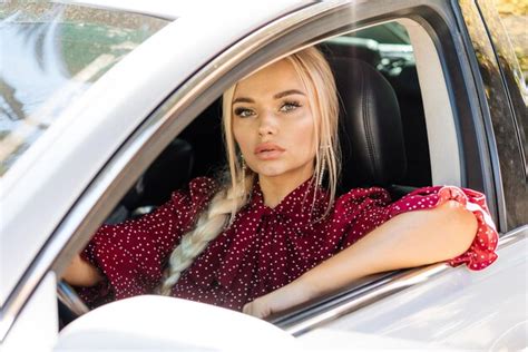Premium Photo Beautiful Successful Blonde Woman In A Red Dress Sitting In A Car Behind The Wheel