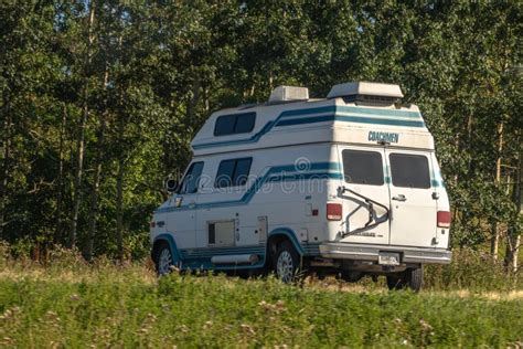 A 90s Coachmen Chevy Van G30 Motorhome With A White Base And Blue
