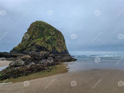 Scenic View Of Haystack Rock On Cannon Beach Oregon With A Cloudy Sky