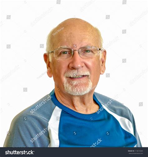 Bald Senior Man With Glasses And A Trimmed White Beard Wearing Blue