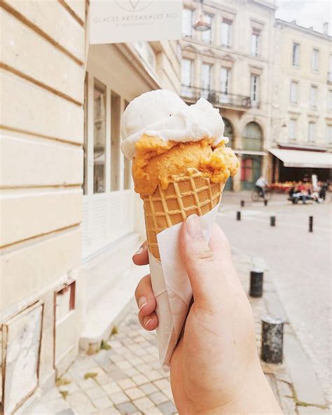 A Hand Holding An Ice Cream Cone On The Side Of A Building With