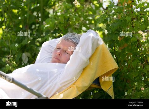 Femme Mature Avec Poils Blancs Dormir Sur Une Chaise Longue Dans Son Jardin Photo Stock Alamy
