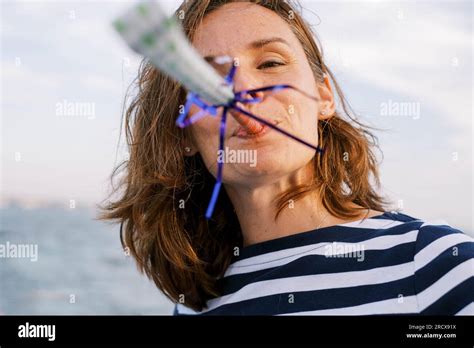 Middle Aged Brunette Woman In Stripes Blowing A Party Favor Stock Photo Alamy