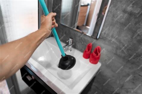 Premium Photo | Sink repair by hand with a toilet plunger plumbing a ...
