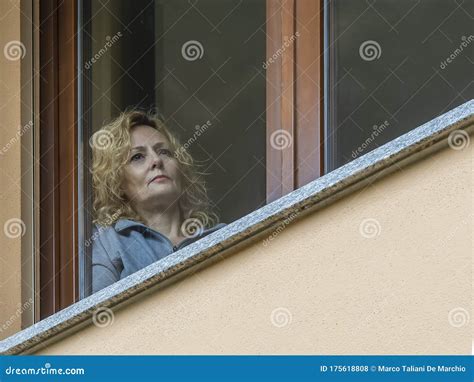 An Italian Blonde Woman Forced To Stay Indoors Because Of Coronavirus Covid Looks At The