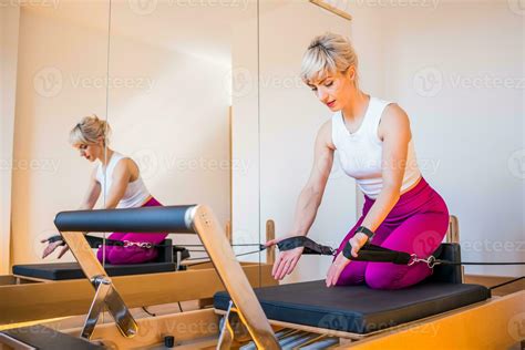 Blonde Woman Is Exercising On Pilates Reformer Bed In Her Home Stock Photo At Vecteezy
