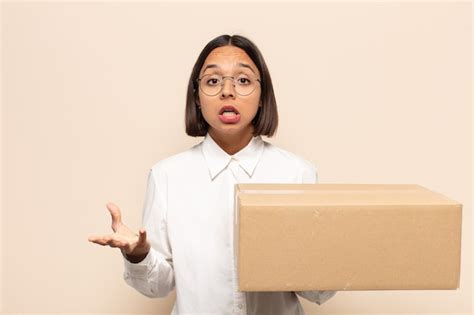 Joven latina que se siente extremadamente conmocionada y sorprendida ansiosa y en pánico con