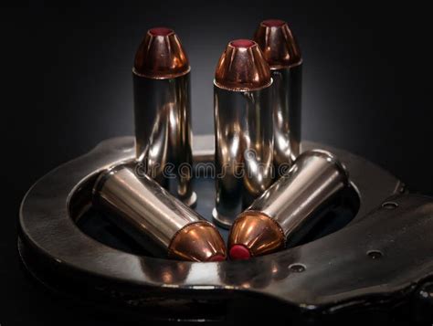 Five Red Tipped Hollow Point 44 Special Caliber Bullets In A Handcuff