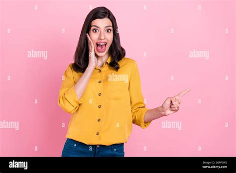 Photo Of Impressed Brunette Hairdo Millennial Lady Point Empty Space Wear Yellow Shirt Isolated