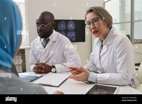 female doctor  white coat talking  colleagues  sitting