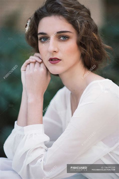 Sensual Brunette Woman In White Dress Looking At Camera Lovely Touching Face Stock Photo
