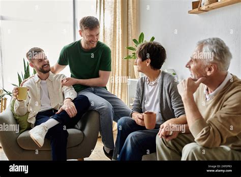 A Gay Couple Shares A Heartwarming Moment With Parents In A Cozy Living Room Setting Stock Photo