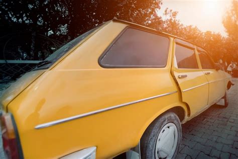 Coche Amarillo Estacionado En Una Calle Soleada De La Ciudad Foto Premium