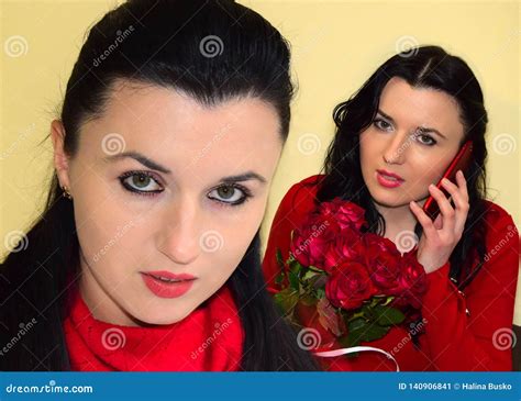 De Jonge Vrouw Het Brunette Is Gekleed In Een Rode Kleding De Vrouw Houdt Een Boeket Van Rode In