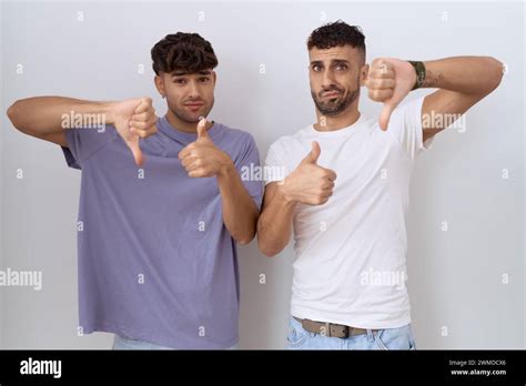 Homosexual Gay Couple Standing Over White Background Doing Thumbs Up