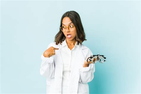 Jovem Oculista Latina Sobre Parede Isolada Surpresa Apontando O Dedo Sorrindo Amplamente