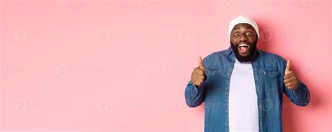 Impressed african-american hipster guy showing thumbs-up, approve and