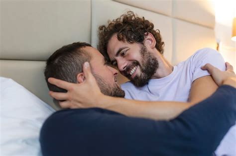 Feliz pareja gay teniendo momentos tiernos en el dormitorio relación de amor homosexual y