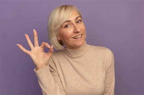 Sourire Jolie Blonde Femme Slave Gestes Ok Signe De La Main Sur Violet Photo Gratuite