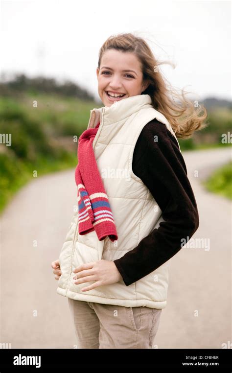 Female Long Blonde Hair Wearing Black Jumper Cream Padded Sleeveless Jacket Pink Knitted Scarf