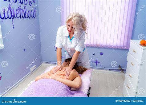 Blonde Massage Therapist Massaging A Woman Woman Getting A Massage At The Spa Stock Image