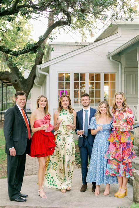 Guests-in-colorful-floral-dresses-standing-together-at-outdoor-cocktail