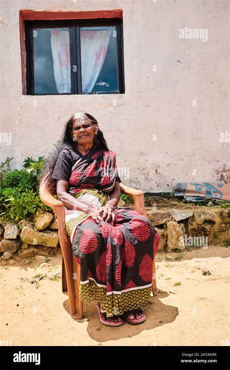 Old Woman Sitting On A Chair In Front Of Her House In Sri Lanka Stock