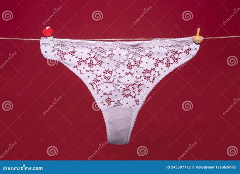 Thong Bikini Bragas Ropa Interior De Encaje Blanco Lencería Sobre Cuerda Aislada En Fondo Rojo